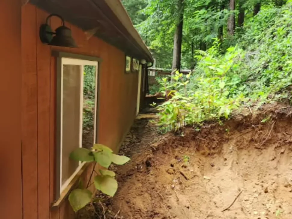 A cut regraded along the side of a house so the water runs away from it