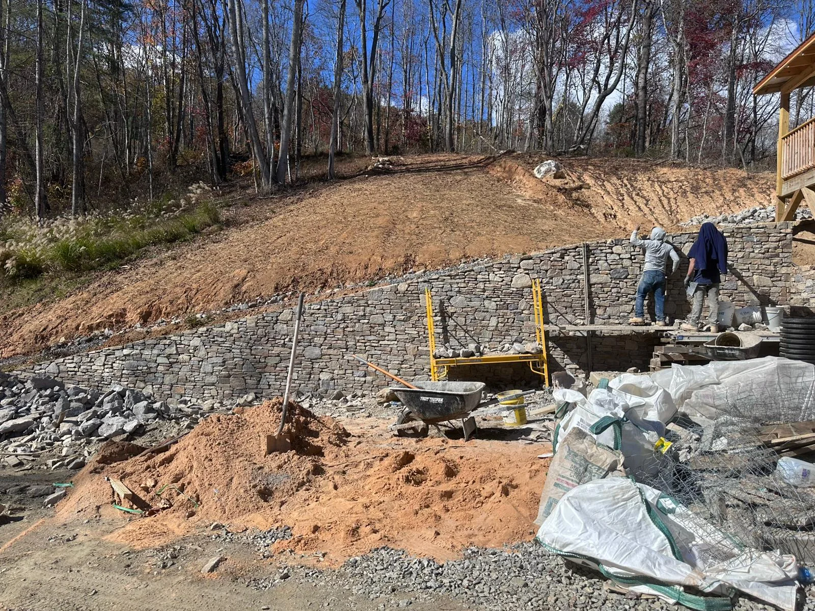 A slope cut back and benched with the stone base going in